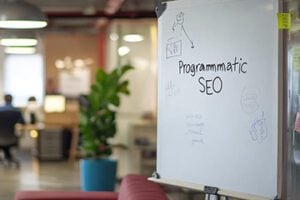 Photo of an office setting with a whiteboard reading "Programmatic SEO."