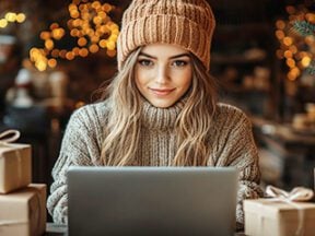 Image of a female using a laptop computer with a Christmas tree in background