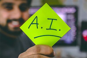 Image of a male holding a paper that reads "A.I."