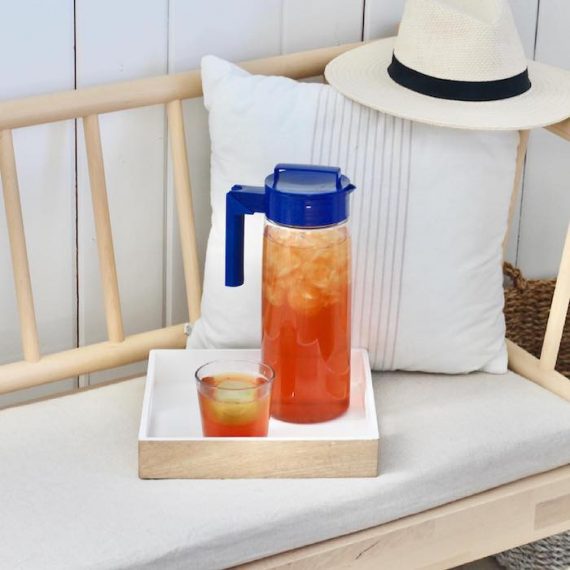 Image of a hat, bottle, and a glass arranged diagonally.