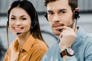 Photo of a male and female wearing headsets for customer support