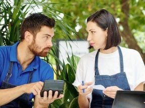 Male and female holding a computer and discussing with each other