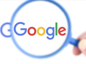 Google logo behind a magnifying glass