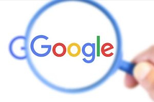 Google logo behind a magnifying glass