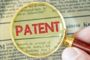 Illustration of the word "Patent" behind a magnifying glass