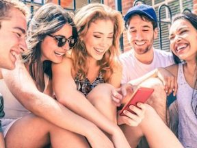 Happy multiracial friends having fun with a smartphone