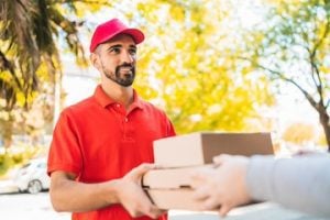 Delivery man carrying packages while making home delivery.