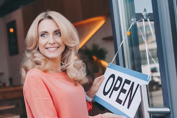 Photo of a female business owner in front of her physical store