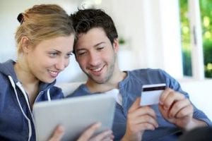 Image of a young married couple shopping on a computer