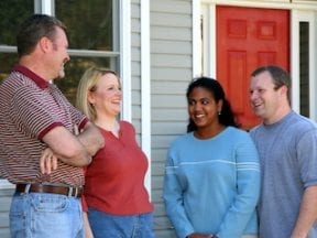 Photo of two couples in front of a local residence