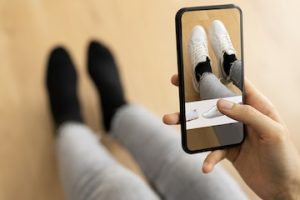 Photo of a shopper virtually trying on shoes on her smarthpone