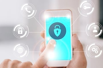 Person holding a smartphone with a cybersecurity icon on the screen