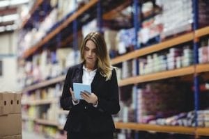 Photo of female in a warehouse holding a tablet