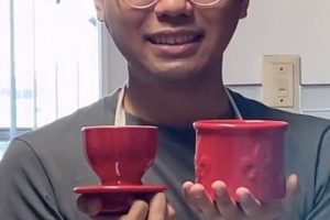 Image of a male holding two red cups for sale