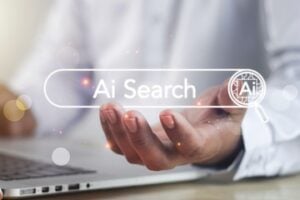 Image of a person working on a laptop with the words "AI Search" superimposed